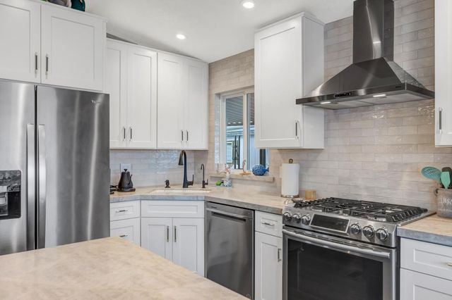 a kitchen with stainless steel appliances a sink stove and refrigerator