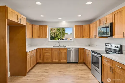 a kitchen with stainless steel appliances granite countertop wooden cabinets a sink and a stove