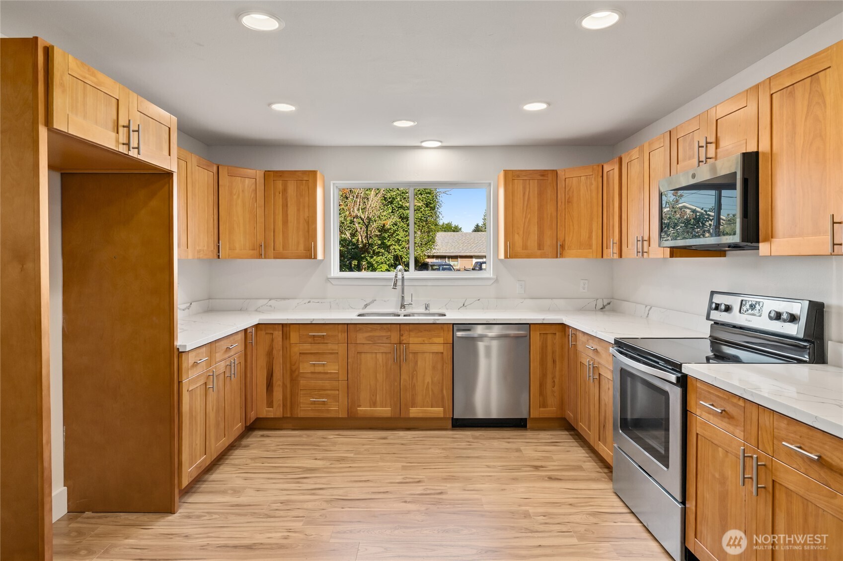 1003 9th Street Northwest Puyallup, WA 98371 - Photo 11 of 40 a kitchen with stainless steel appliances granite countertop wooden cabinets a sink and a stove