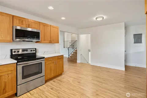 a kitchen with stainless steel appliances granite countertop a stove a sink and a microwave