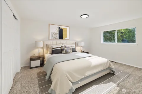 a bedroom with a bed and a painting on the wall