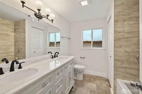 a bathroom with a double vanity sink a toilet and a mirror