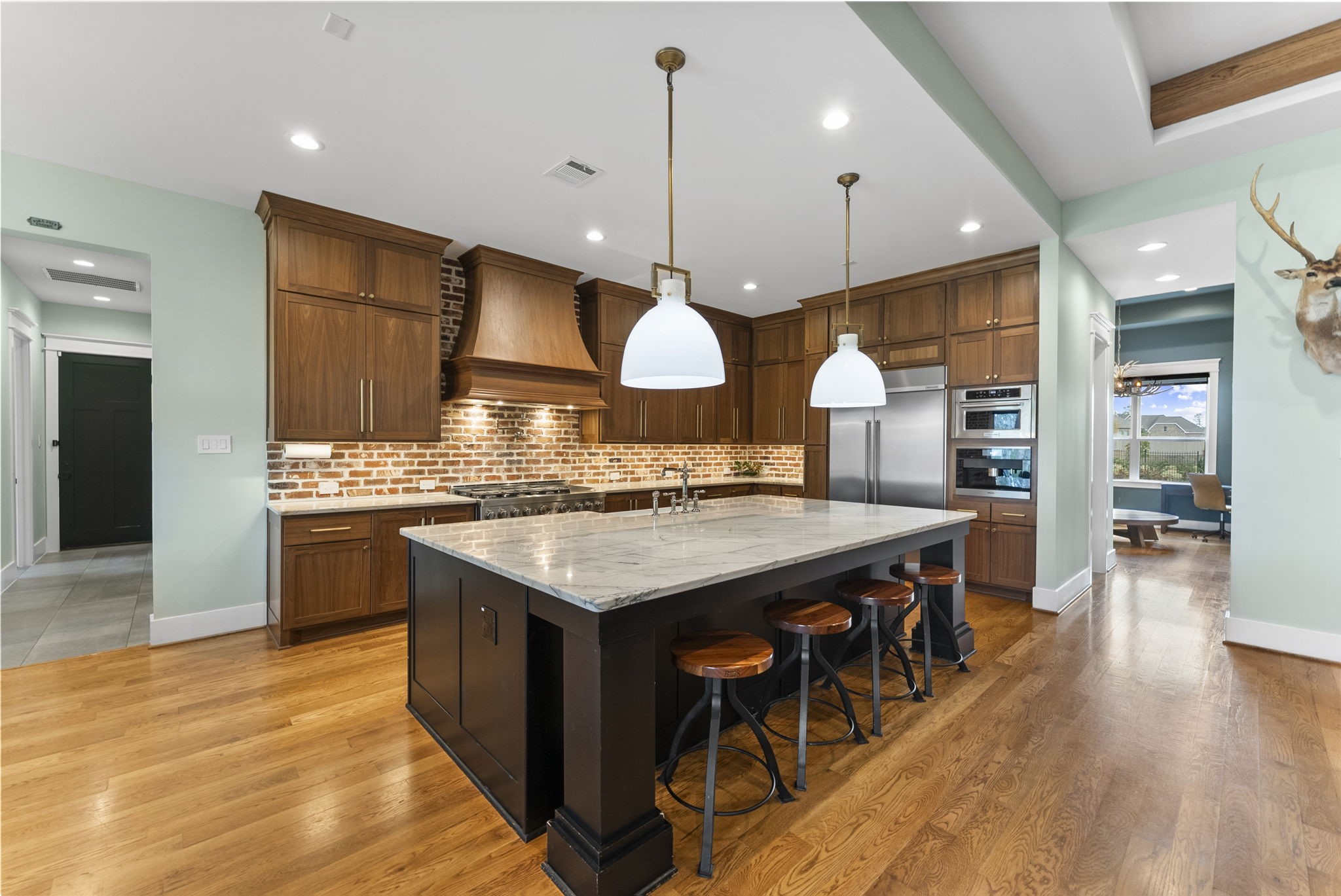 14019 Beartooth Bend Trail Conroe, TX 77384 - Photo 10 of 28 Gourmet chef’s kitchen with marble countertops, oversized island, brick backsplash, and custom cabinetry complete with custom pull outs and organizers throughout.