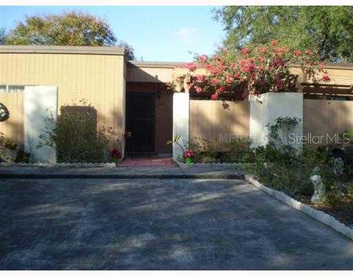 a view of a house with a yard next to a lake