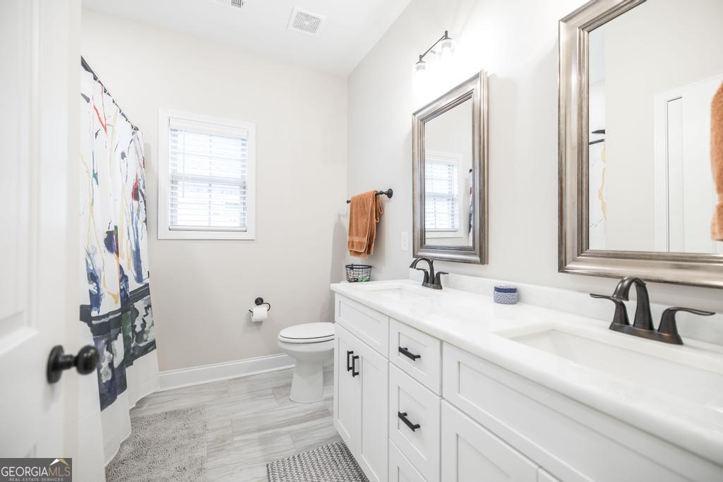 111 Fieldview Lane Kathleen, GA 31047 - Photo 26 of 36 a bathroom with a double vanity sink toilet and a mirror