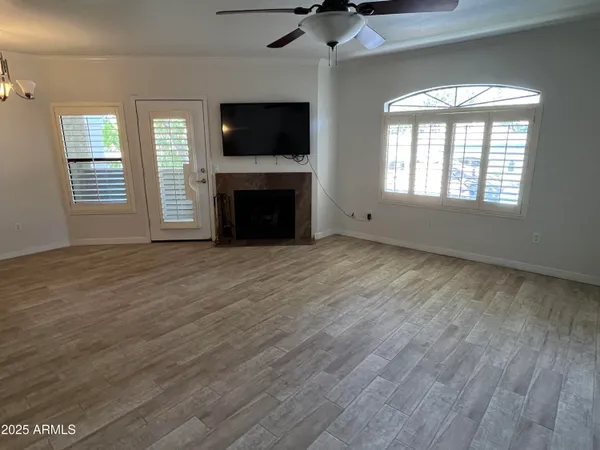 a view of an empty room with a window and wooden floor