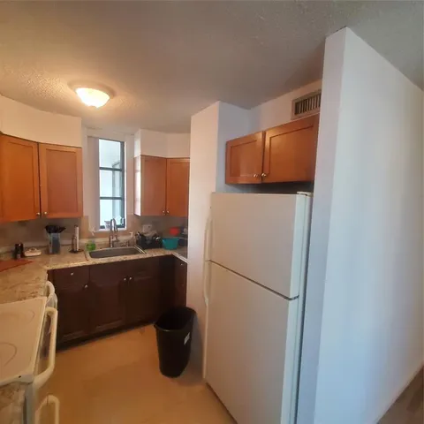 a kitchen with sink refrigerator and cabinets