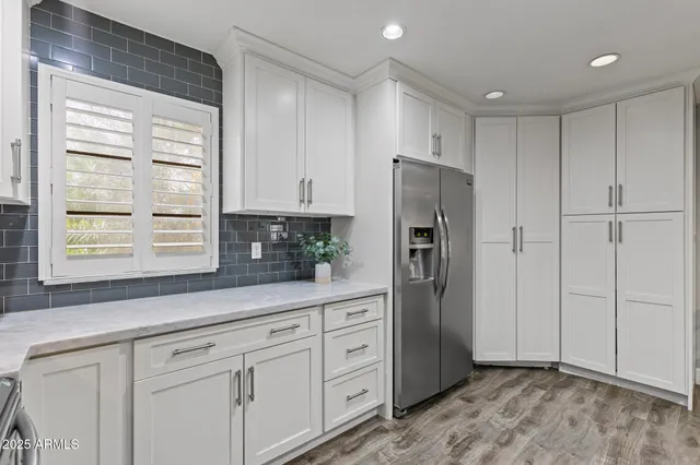 a kitchen with stainless steel appliances white cabinets and a window