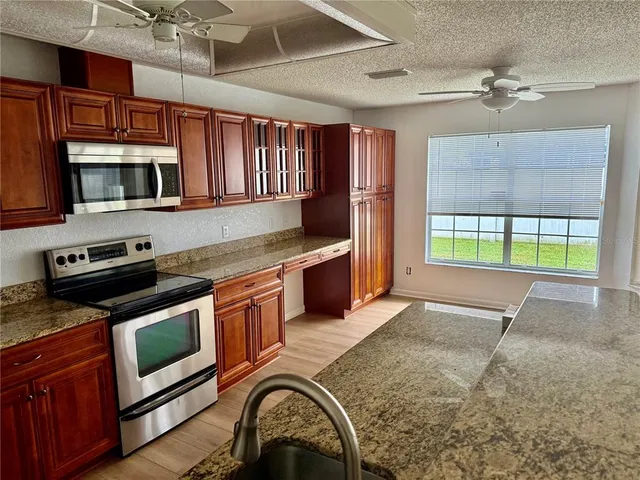 a kitchen with stainless steel appliances granite countertop a stove a microwave and a refrigerator