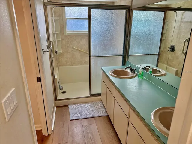 a bathroom with a sink a mirror and shower