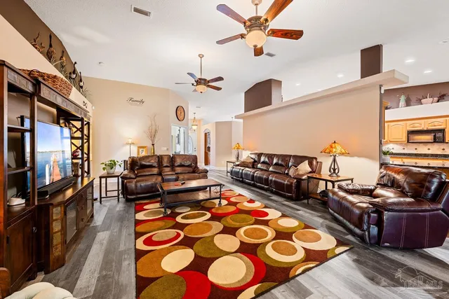 a living room with patio chairs and a flat screen tv