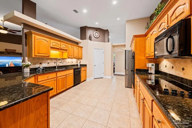 a kitchen with stainless steel appliances granite countertop a stove a sink and a microwave