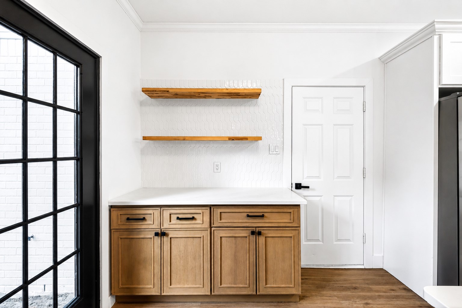 523 Rampart Lane Conroe, TX 77302 - Photo 11 of 41 A thoughtfully designed coffee and beverage station showcasing custom cabinetry, quartz surfaces, floating wood shelves, adding both style and functionality to this beautifully renovated home.