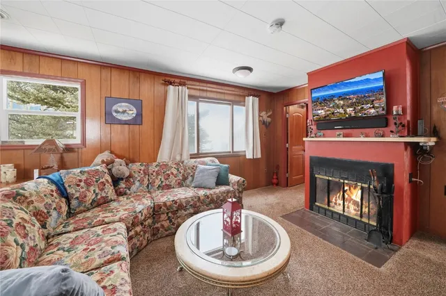 a living room with furniture a fireplace and a window