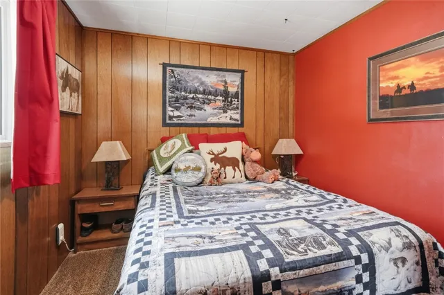 a bedroom with a bed and a lamp on dresser