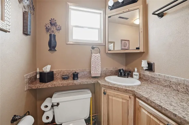a bathroom with a granite countertop sink and a mirror