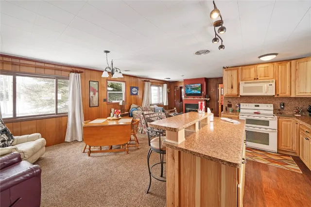 a kitchen with stainless steel appliances kitchen island granite countertop a stove and white cabinets