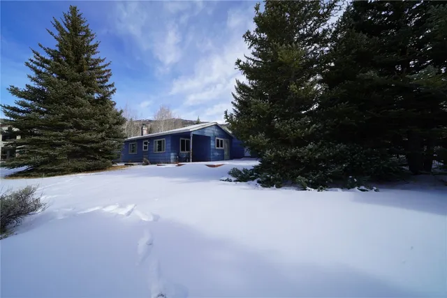 a front view of a house with a yard covered in snow