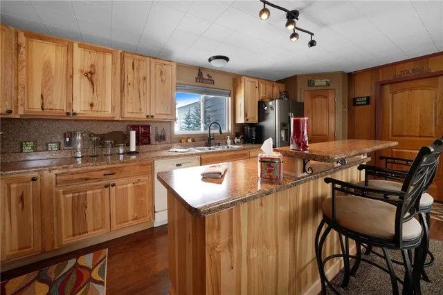 a kitchen with stainless steel appliances granite countertop a sink dishwasher and cabinets with wooden floor