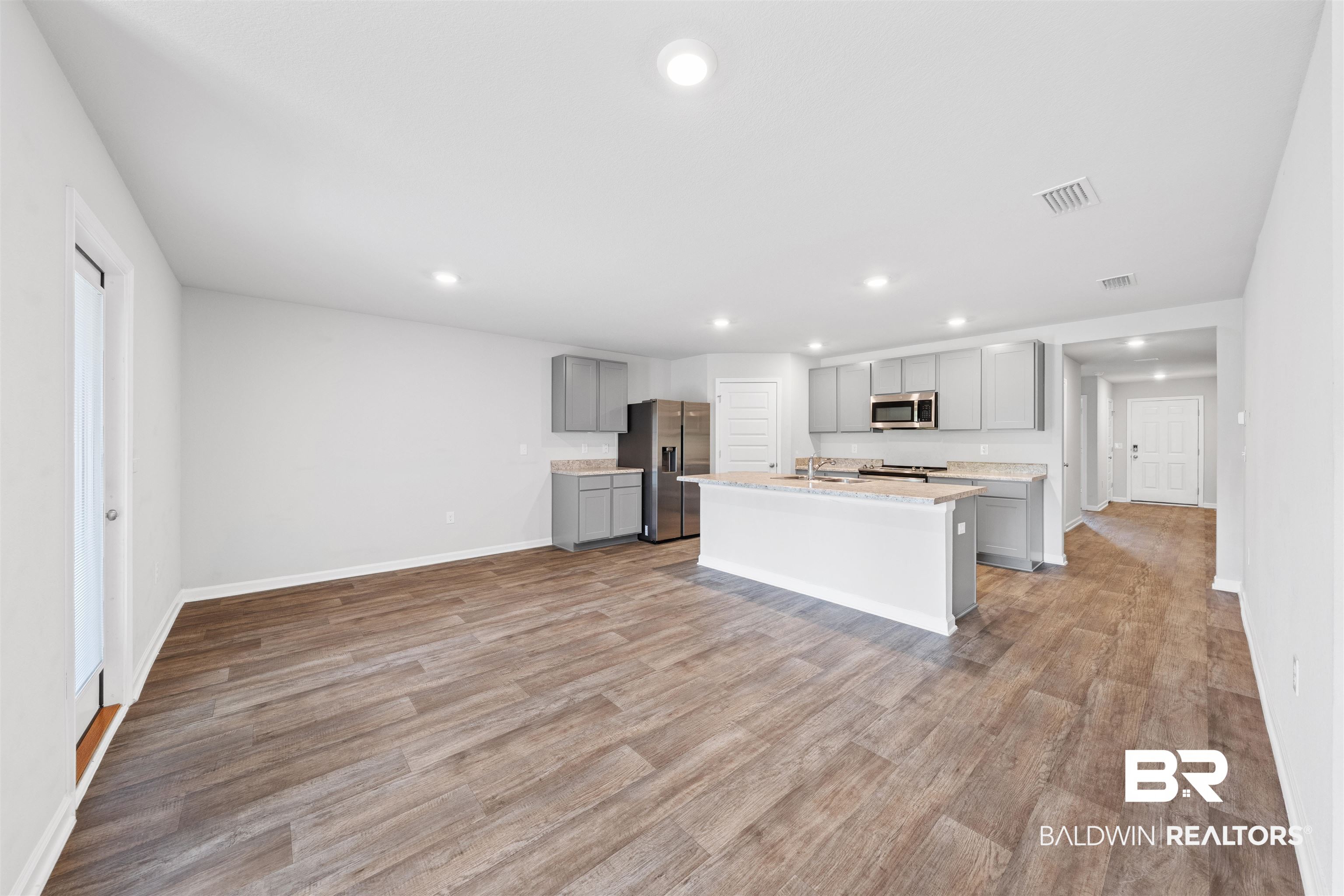 7457 Brompton Drive Foley, AL 36535 - Photo 6 of 24 Kitchen featuring gray cabinets, recessed lighting, stainless steel appliances, light wood finished floors, and light stone counters