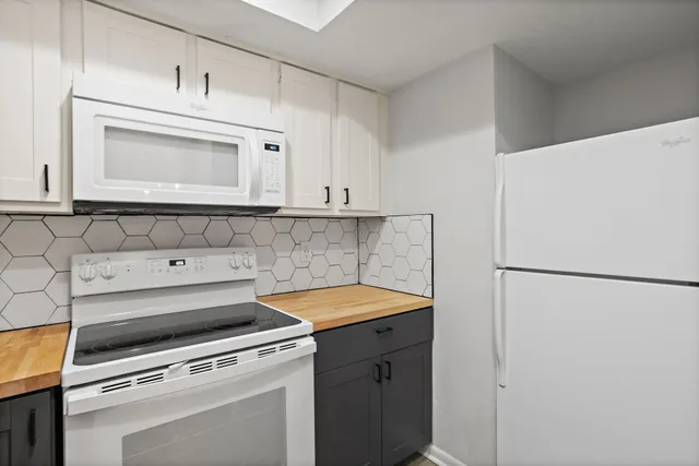 a kitchen with a refrigerator sink stove and cabinets