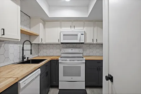 a kitchen with stainless steel appliances granite countertop a sink stove and cabinets