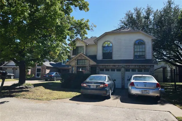 a front view of a house with cars parked