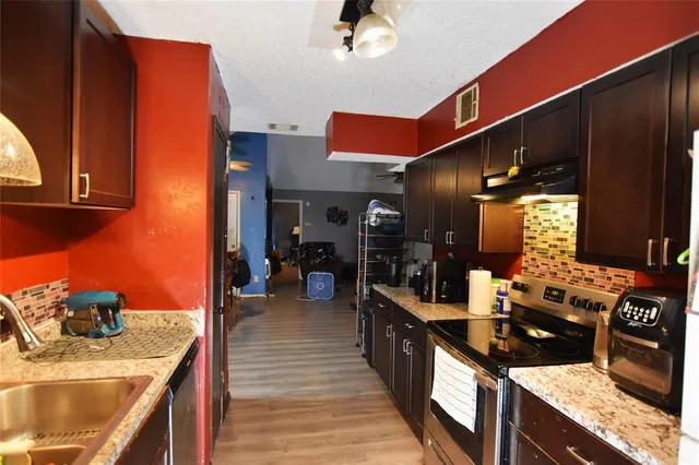a kitchen with stainless steel appliances granite countertop a sink stove and cabinets