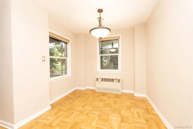 a view of a bedroom with wooden floor and a window