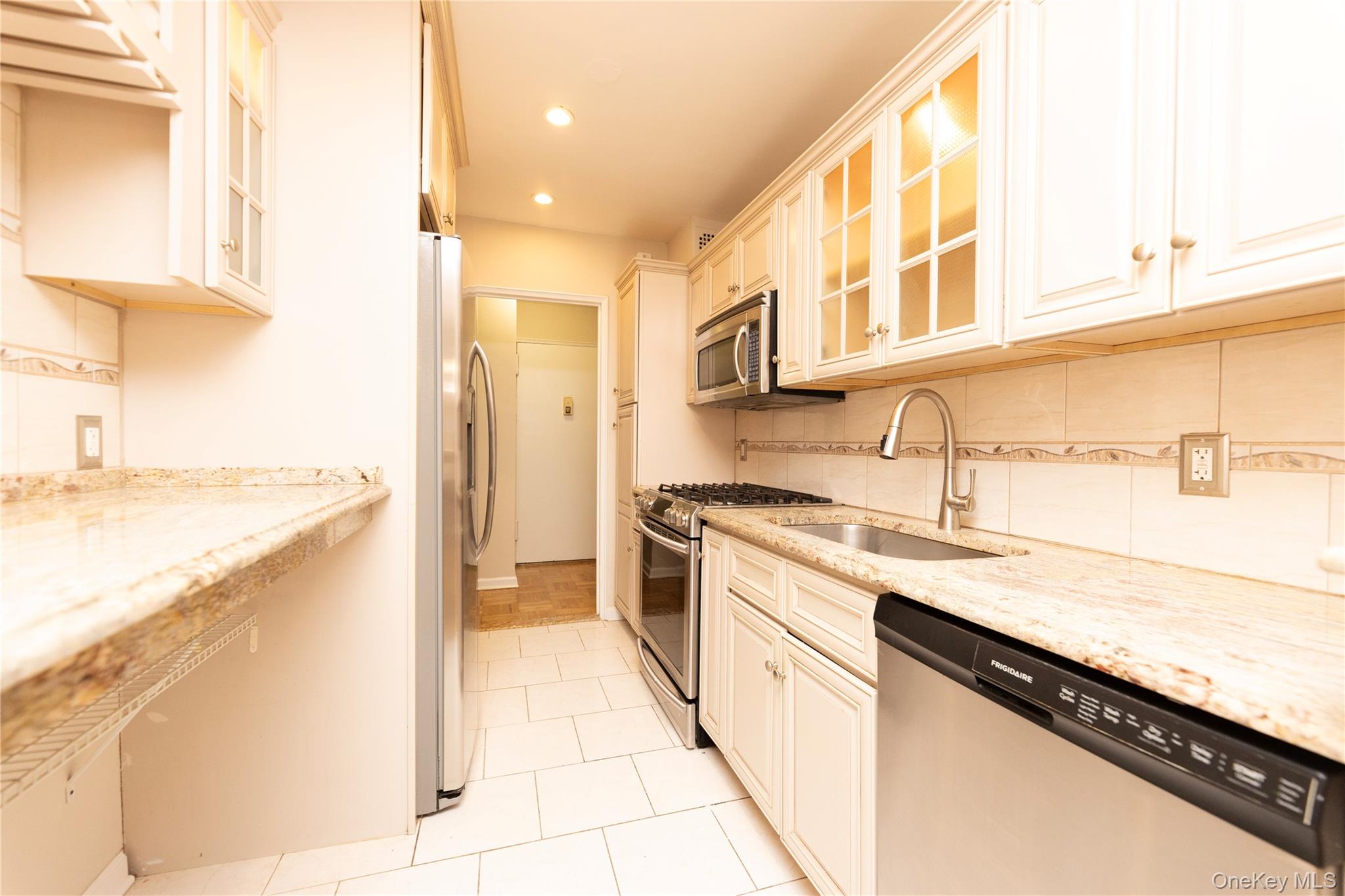 5550 Fieldston Road, Unit 1C ON 2 Bronx, NY 10471 - Photo 18 of 22 a kitchen with stainless steel appliances granite countertop a sink and a stove