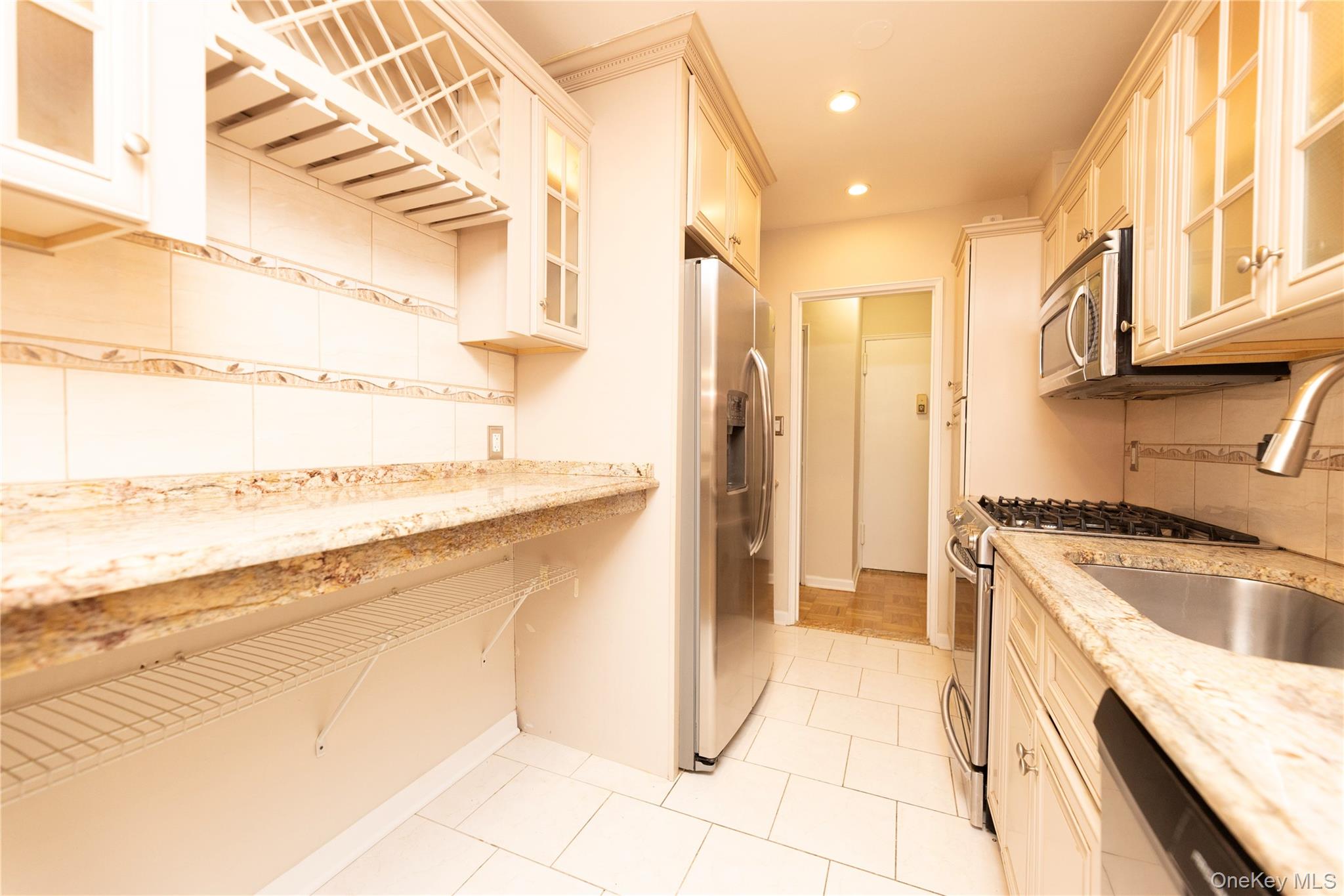 5550 Fieldston Road, Unit 1C ON 2 Bronx, NY 10471 - Photo 19 of 22 a kitchen with a stove a sink and a refrigerator