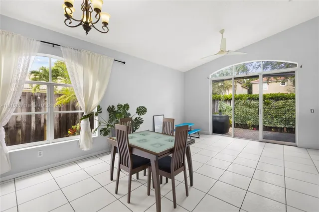 a dining room with furniture a chandelier and wooden floor