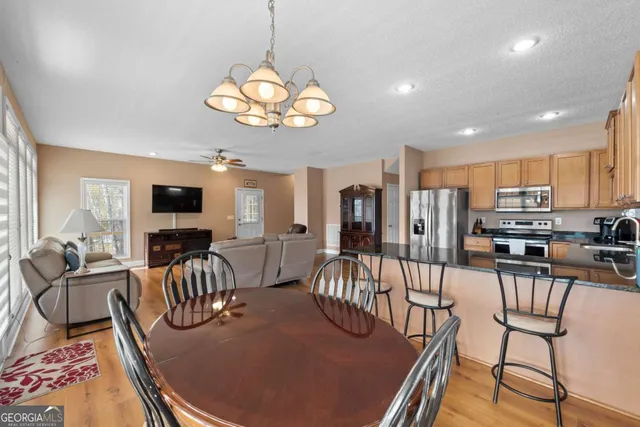 a view of a dining room with furniture a chandelier and wooden floor