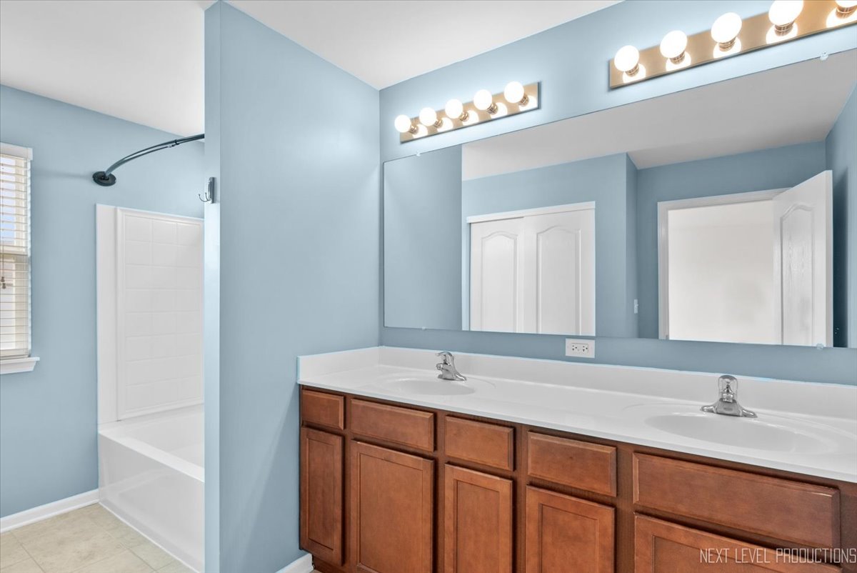 5734 Oak Ridge Way Lisle, IL 60532 - Photo 14 of 28 a bathroom with double sink and a mirror