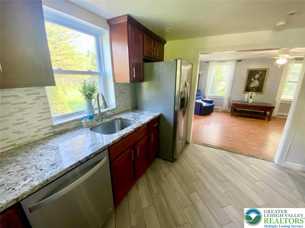 244 Learn Road Tannersville, PA 18372 - Photo 30 of 69 a kitchen with stainless steel appliances granite countertop a sink a stove and a wooden floors