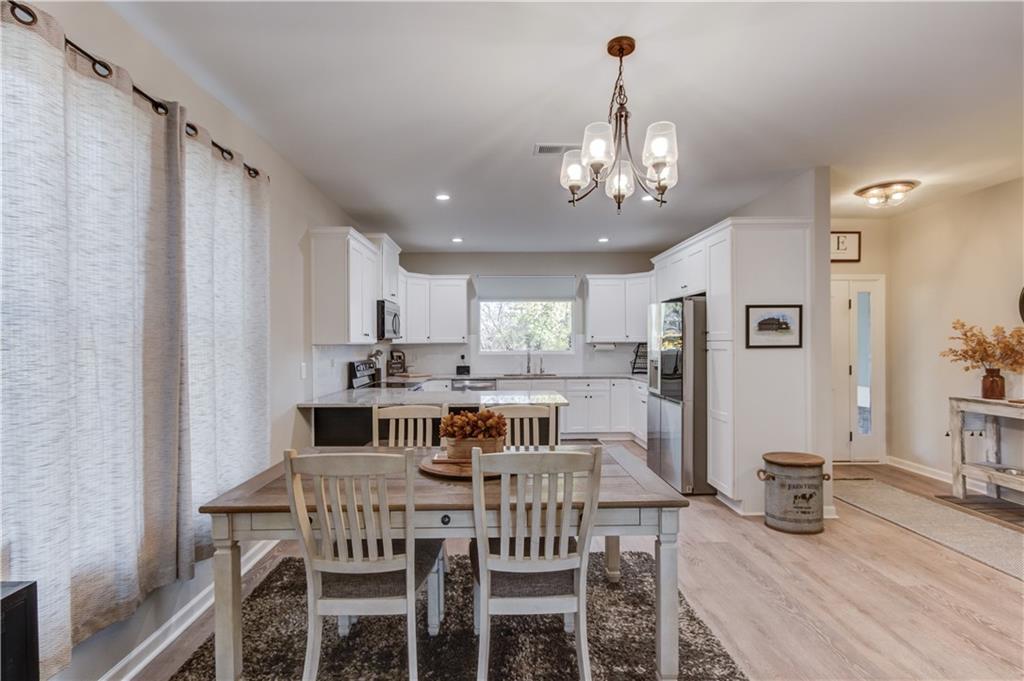 6137 Timberidge Drive Gainesville, GA 30506 - Photo 13 of 50 a view of a dining room with furniture a kitchen and chandelier