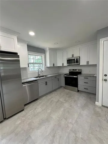 a large kitchen with cabinets and stainless steel appliances