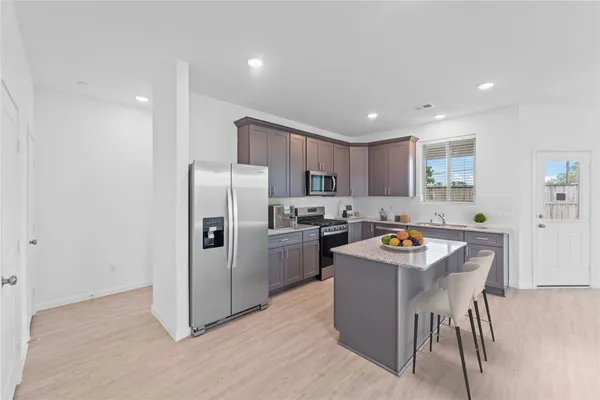 a kitchen with stainless steel appliances granite countertop a refrigerator sink and stove