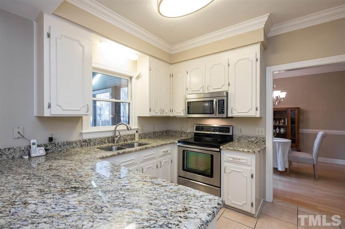 7921 Footman Way Raleigh, NC 27615 - Photo 11 of 28 a kitchen with stainless steel appliances granite countertop a sink stove and microwave