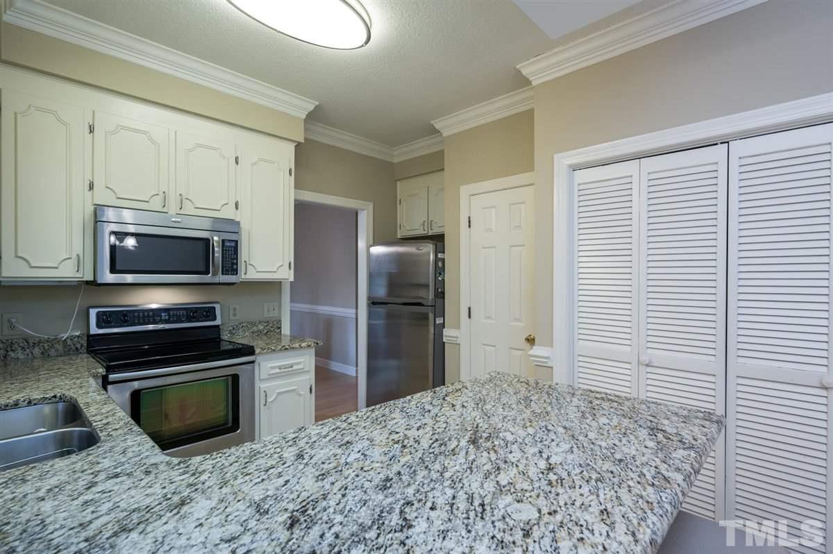7921 Footman Way Raleigh, NC 27615 - Photo 13 of 28 a kitchen with granite countertop a refrigerator and a sink