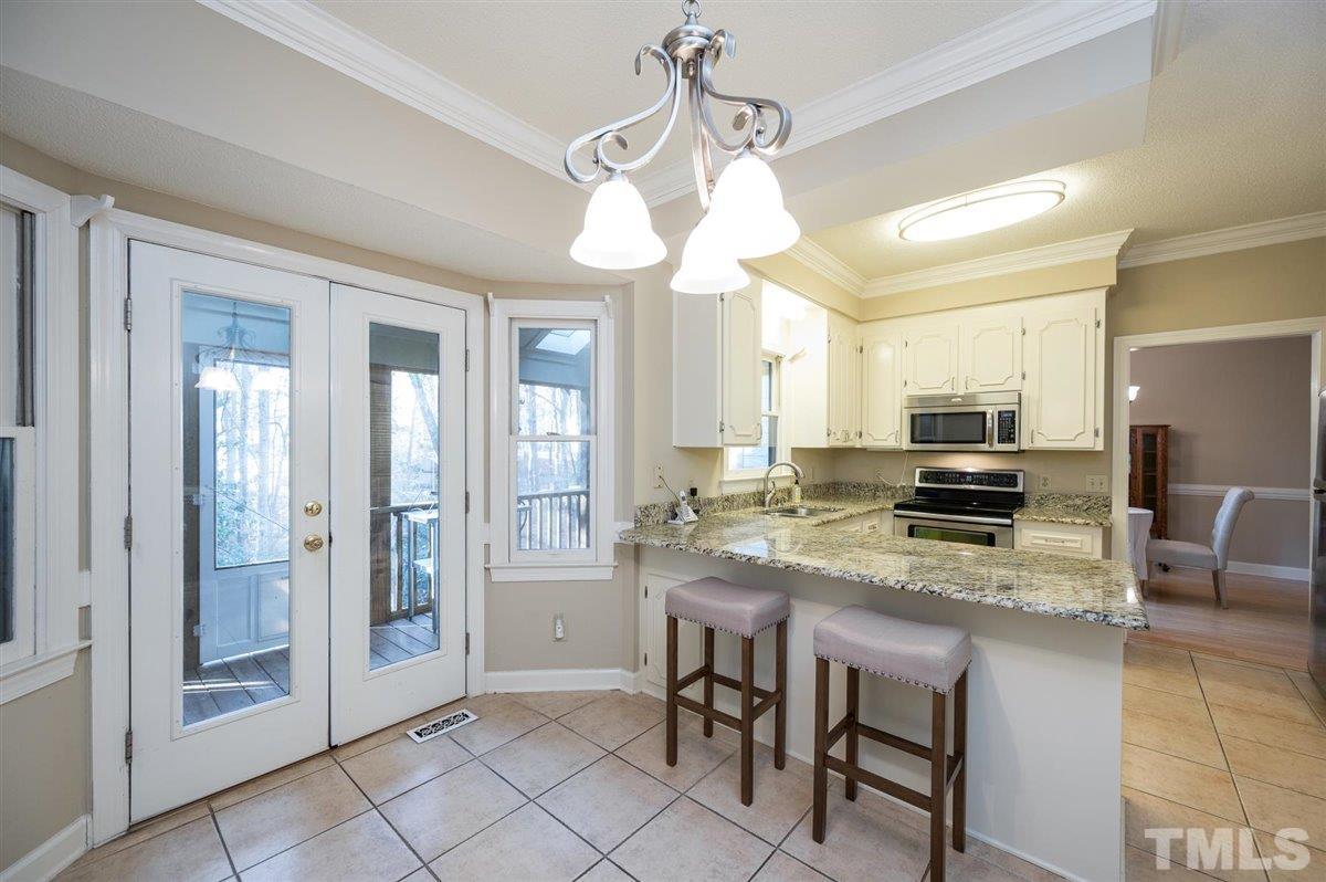 7921 Footman Way Raleigh, NC 27615 - Photo 15 of 28 a kitchen with a table chairs refrigerator and microwave