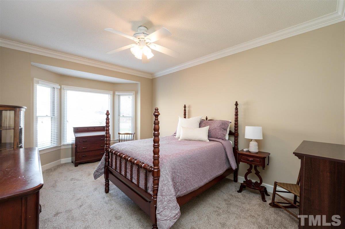 7921 Footman Way Raleigh, NC 27615 - Photo 16 of 28 a bedroom with a bed and a chandelier