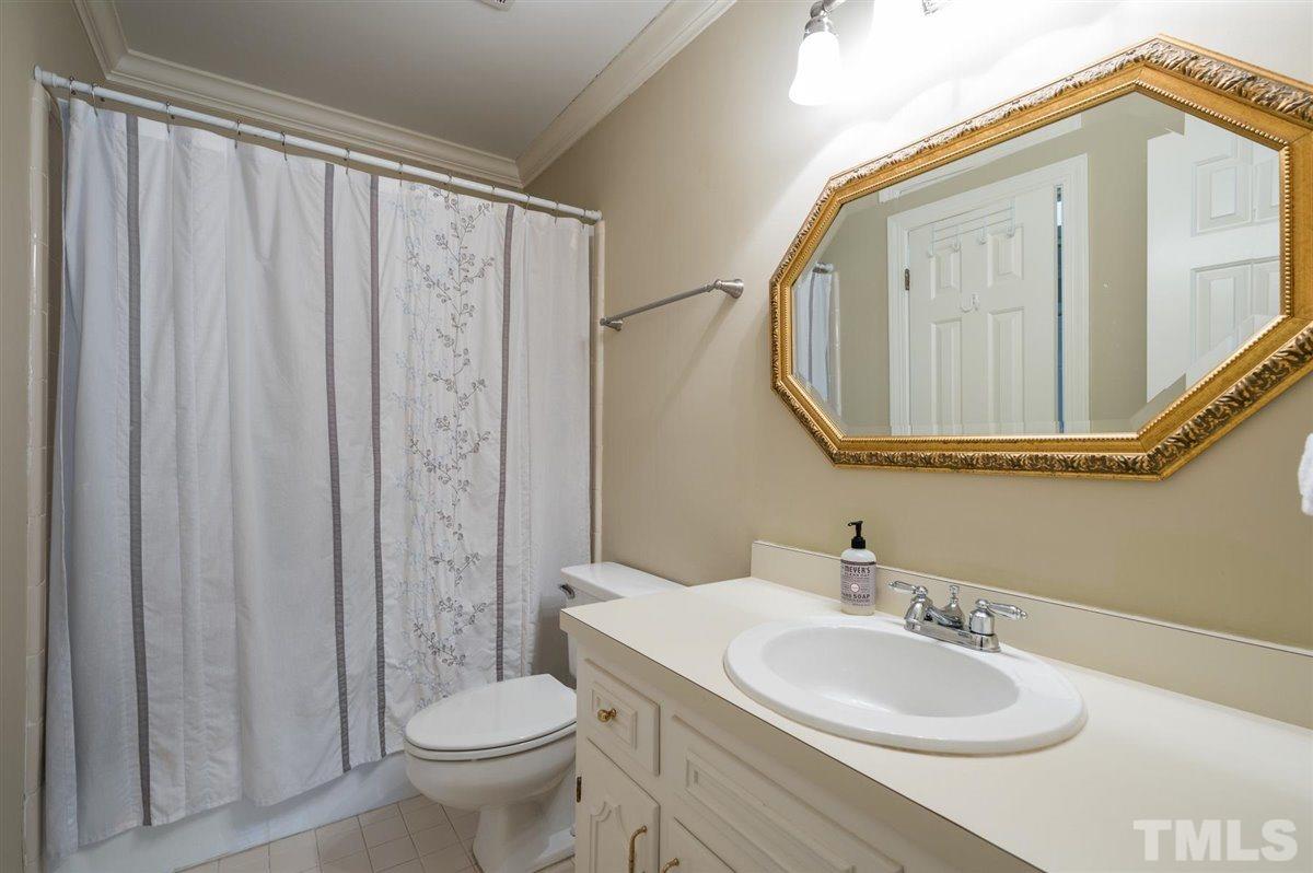 7921 Footman Way Raleigh, NC 27615 - Photo 19 of 28 a bathroom with a toilet a sink and a mirror