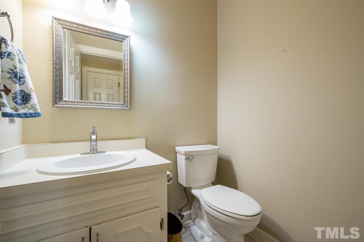 7921 Footman Way Raleigh, NC 27615 - Photo 22 of 28 a bathroom with a toilet sink and mirror