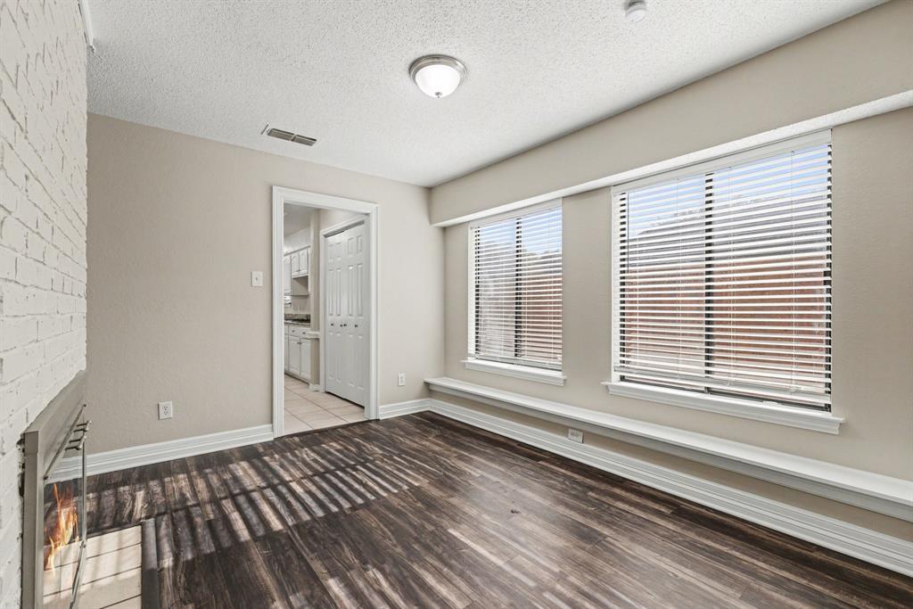 505 Springhill Drive Hurst, TX 76054 - Photo 11 of 25 a view of an empty room with wooden floor and a window