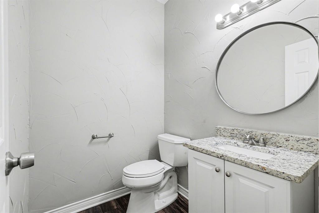 505 Springhill Drive Hurst, TX 76054 - Photo 13 of 25 a bathroom with a granite countertop toilet sink and mirror