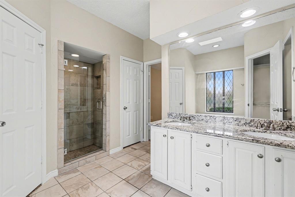 505 Springhill Drive Hurst, TX 76054 - Photo 15 of 25 a bathroom with a granite countertop sink mirror and shower