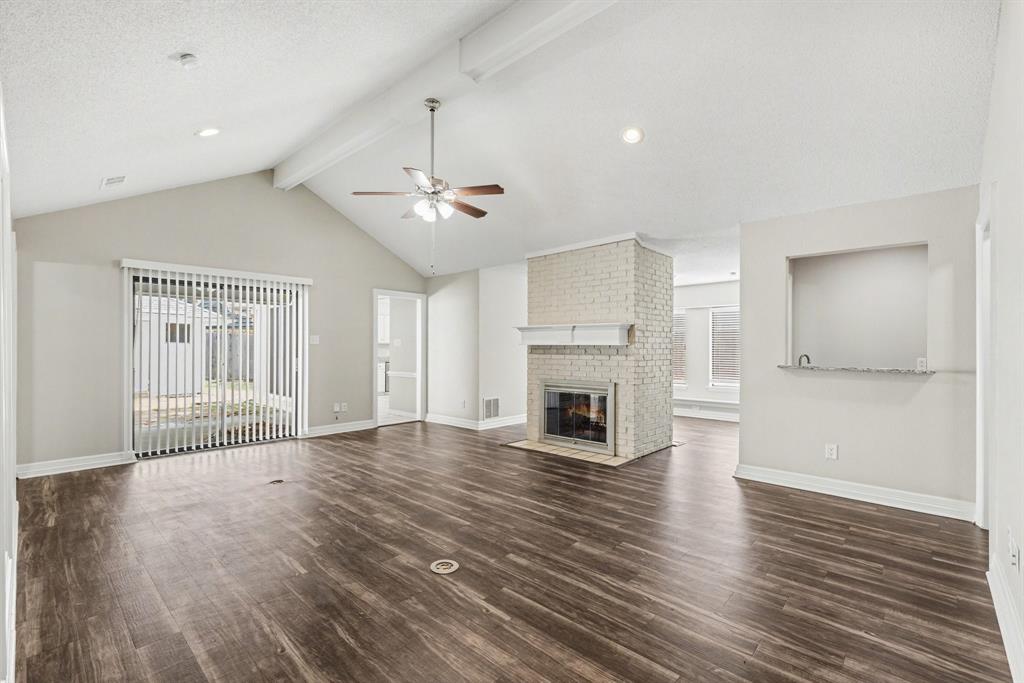 505 Springhill Drive Hurst, TX 76054 - Photo 4 of 25 an empty room with wooden floor fireplace and windows