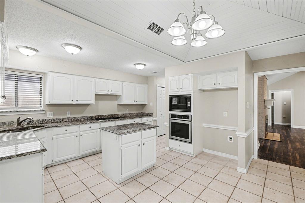 505 Springhill Drive Hurst, TX 76054 - Photo 8 of 25 a kitchen with white cabinets and stainless steel appliances