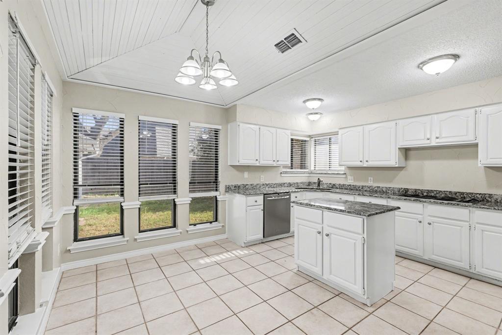505 Springhill Drive Hurst, TX 76054 - Photo 9 of 25 a large kitchen with granite countertop a stove a sink a dining table and chairs